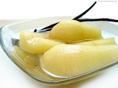 three pieces of fruit in a glass dish on a white surface with a black string