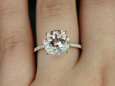 a woman's hand with a ring on it and a diamond in the middle