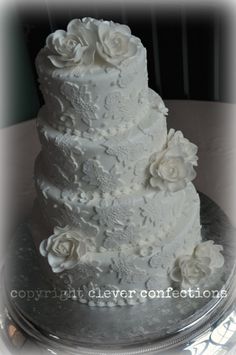 a three tiered wedding cake with white frosting flowers on the top and bottom