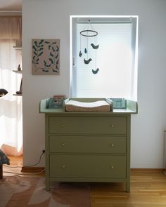 a baby's crib in the corner of a room next to a window