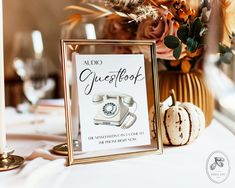 an old fashioned phone sits on a table next to a vase with flowers and candles