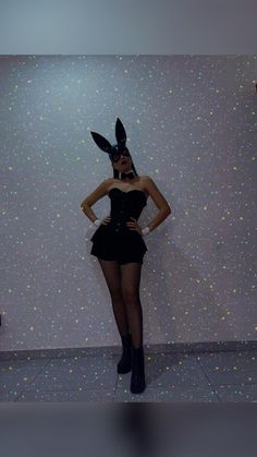 a woman in a bunny costume poses for the camera with her hands on her hips