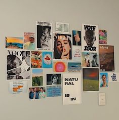 a white refrigerator covered in pictures and magnets next to a wall mounted light switch