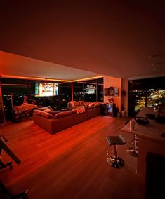 a living room filled with furniture next to a window covered in bright red lights at night