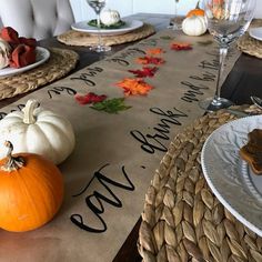 the table is set with pumpkins and place settings