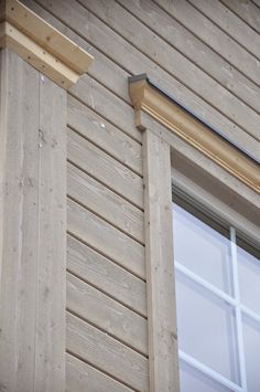 the side of a house with wood siding and window trims on it's sides