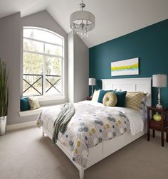 a bedroom with teal walls and white bedding in the center, along with a chandelier hanging from the ceiling