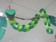 a person holding up a piece of paper that has been cut into the shape of a snake