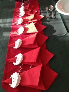 the table is set up with red napkins and silverware on top of it