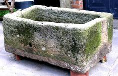 a large stone planter sitting on top of a sidewalk