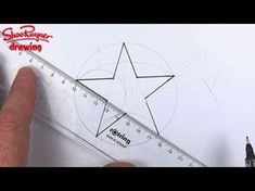 someone is drawing a star on paper with a ruler and marker pen in front of it