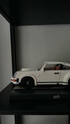 a lego model of a white sports car on a black table with the word joli written below it