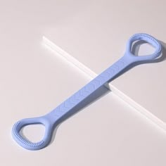 a pair of blue scissors sitting on top of a white table next to a ruler