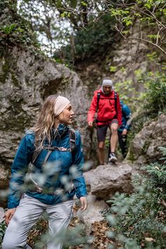 two people hiking up a rocky trail in the woods