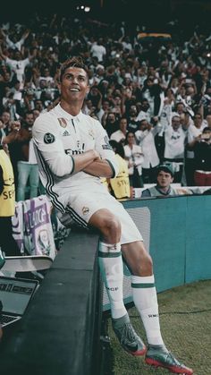 a man sitting on top of a bench in front of a crowd