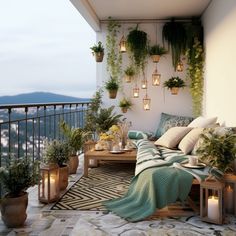 a balcony with potted plants and candles on the table, next to a couch