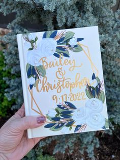 a hand holding up a book with the words baby and christ in gold foil on it