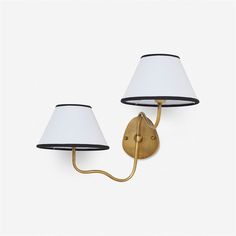 two wall lamps with white shades on them