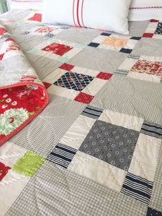 a quilted bed with red and white pillows