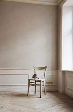 a chair sitting in an empty room next to a window