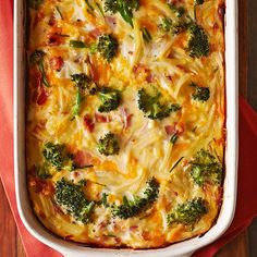 a casserole dish with broccoli and cheese in it on a red napkin