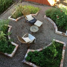 an outdoor seating area in the middle of a graveled yard with chairs and plants