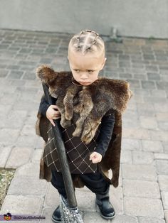 a little boy dressed up as a child with a fur stoler on his shoulders