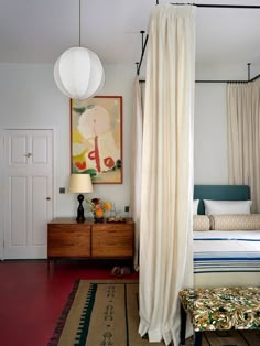 a bedroom with a canopy bed and white curtains