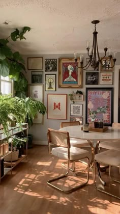 a dining room table with chairs and pictures on the wall in front of it's windows