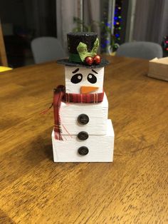 a snowman sitting on top of a wooden table