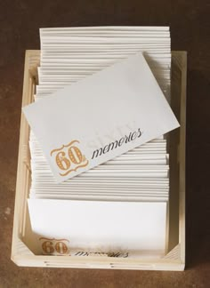 several folded papers in a box with the word monogram written on one side and two letters at the other end