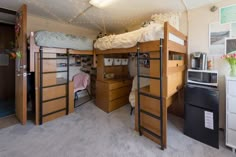 a bedroom with bunk beds and desks in it