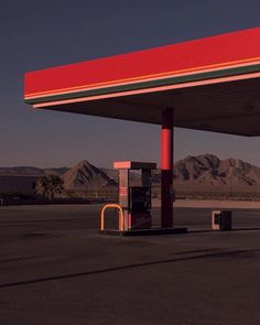 an empty gas station with mountains in the background