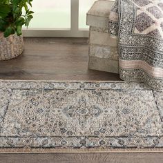 an area rug is on the floor next to a potted plant and window sill