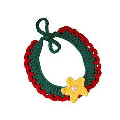 a crocheted bracelet with a yellow flower and green ribbon around it on a white background