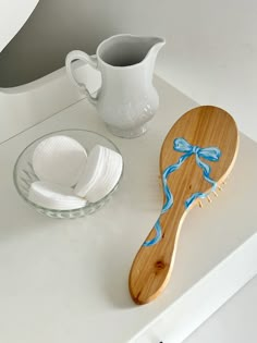 a wooden spoon sitting on top of a counter next to a cup and saucer