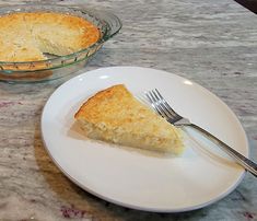 a piece of pie sitting on top of a white plate next to a glass bowl