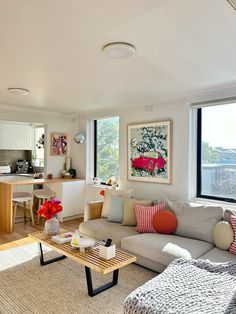 a living room filled with furniture next to a kitchen