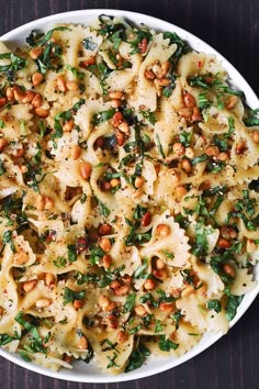 pasta with spinach and chickpeas in a white bowl on a wooden table