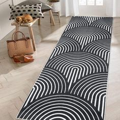 a black and white area rug with an abstract design on the floor in front of a window