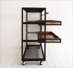 a metal and wood shelf with drawers on wheels