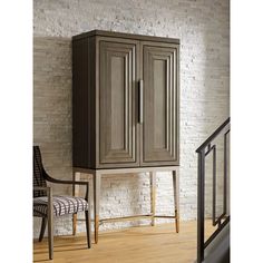 a tall wooden cabinet sitting next to a chair on top of a hard wood floor