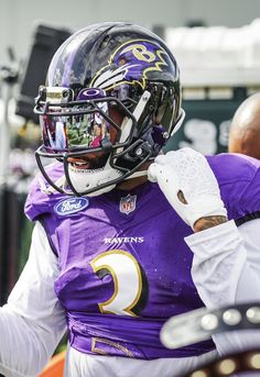 a football player wearing a purple uniform and white gloves