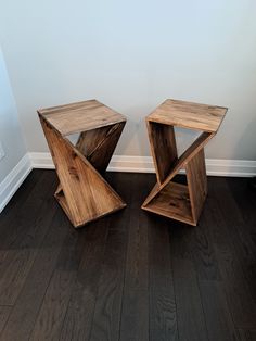 two wooden tables sitting on top of a hard wood floor next to a white wall