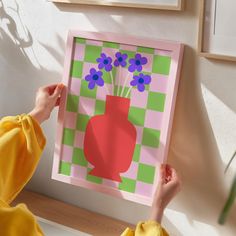 a person holding up a paper cut out of a vase with flowers