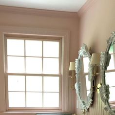 a bathroom with two mirrors and a sink in it's corner next to a window