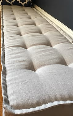 a white couch sitting on top of a hard wood floor next to a black wall