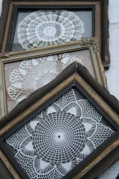 two framed pictures with white doily on them, one is black and the other is white