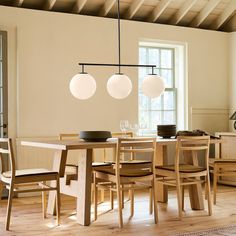 a dining room table and chairs in front of a window