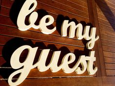 a wooden sign that says be my guest on the side of a building with wood slats